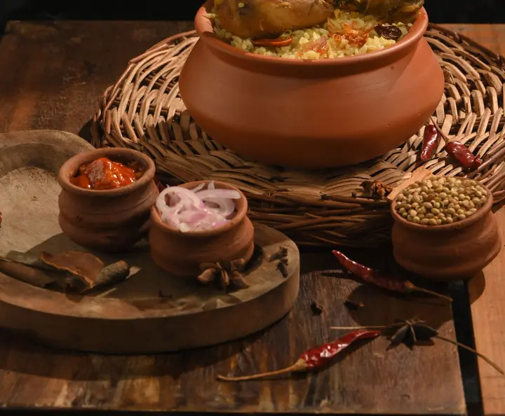 Whole spices around a clay pot (stock photo)