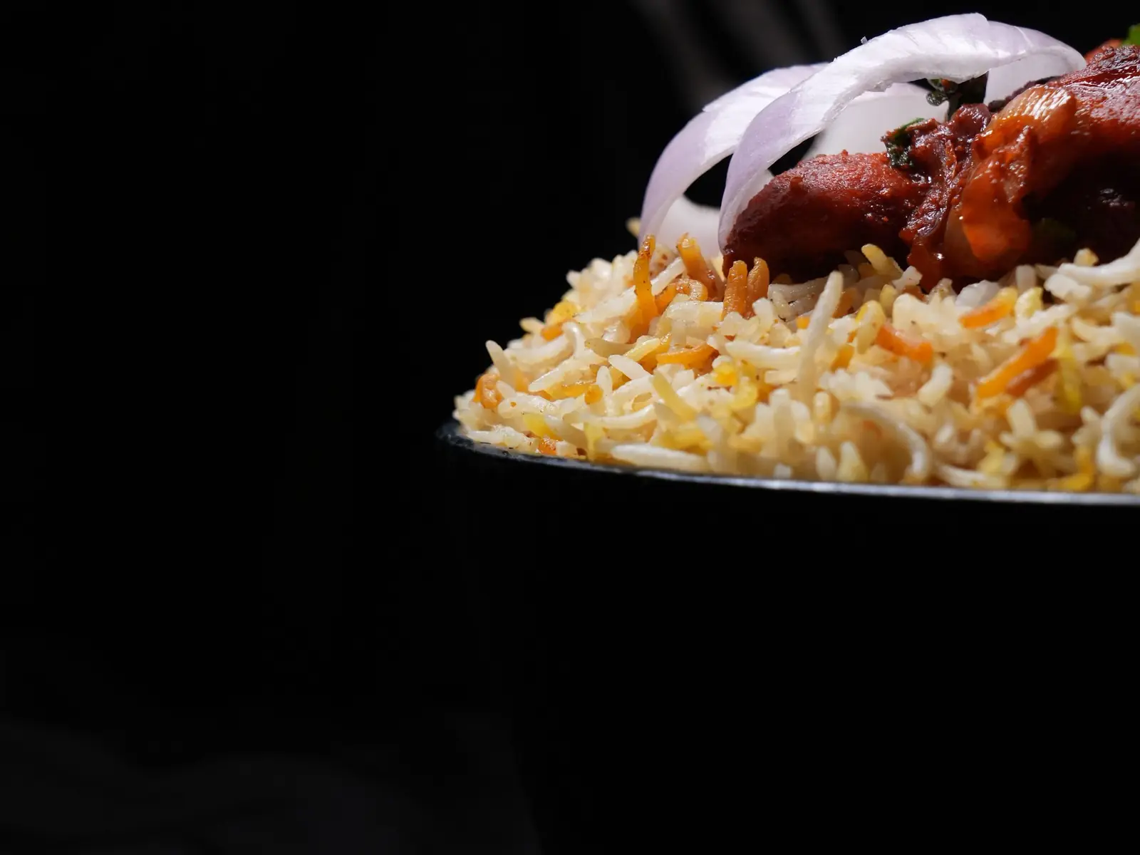 A spoonful of biryani with chicken and onion (stock photo)